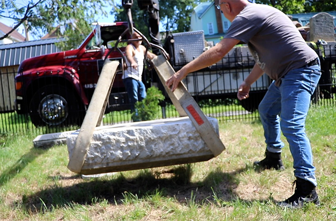 tombstone being lifted by a winch