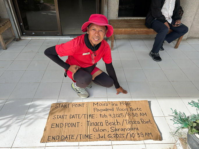 Lito with cardboard sign of his itinerary