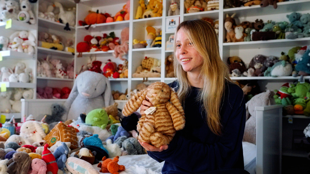 Girl holding up a brown striped toy bunny