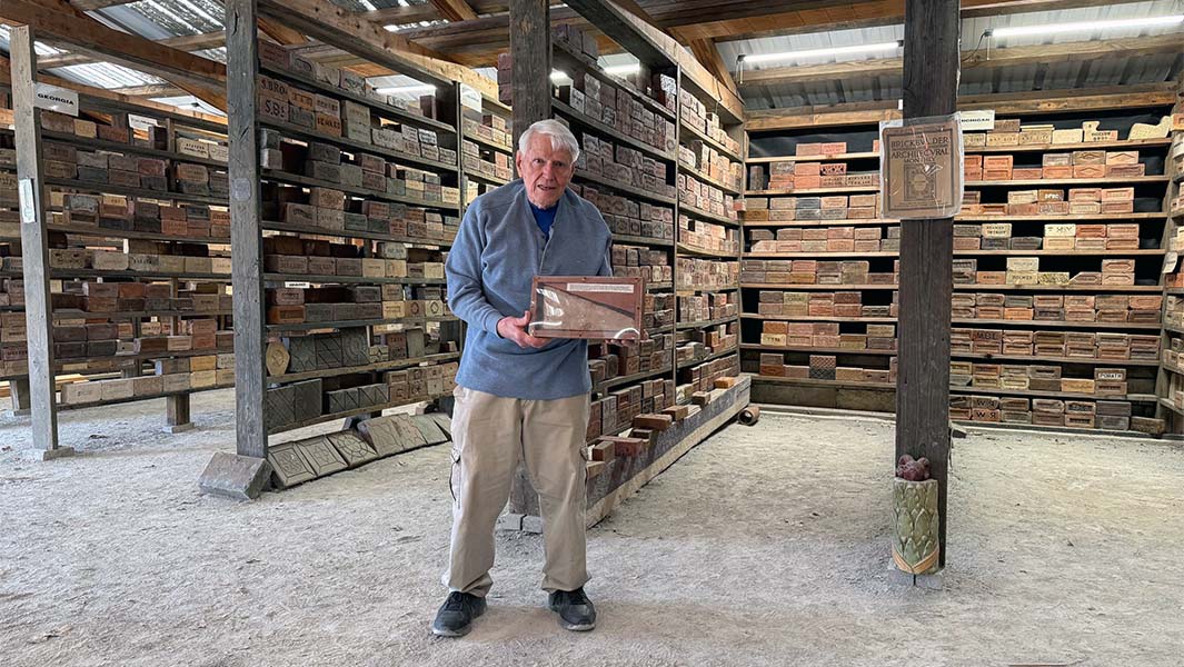 Clem posing in his barn full of bricks