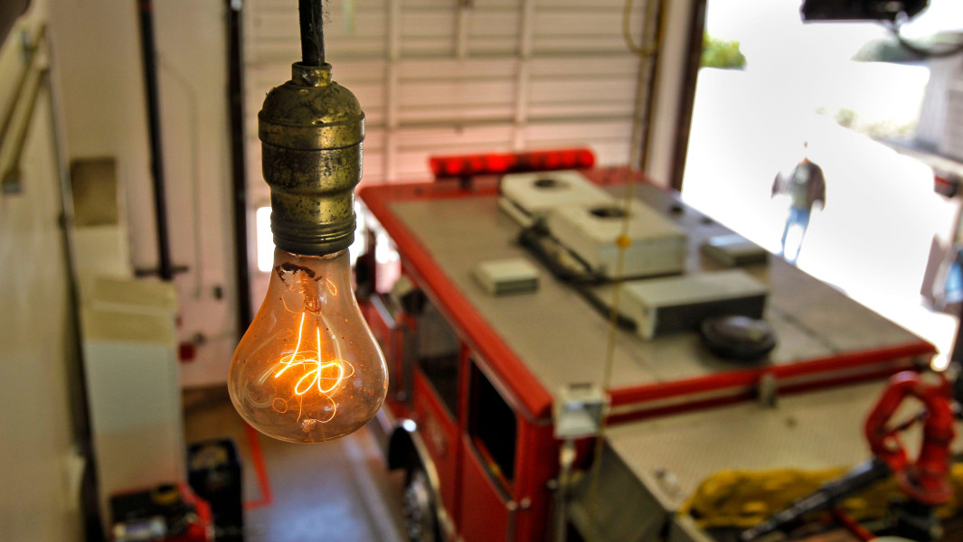 Oldest running lightbulb shining above a fire truck
