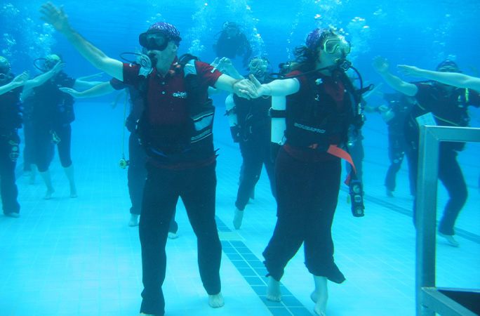 Couples dancing underwaer in scuba gear