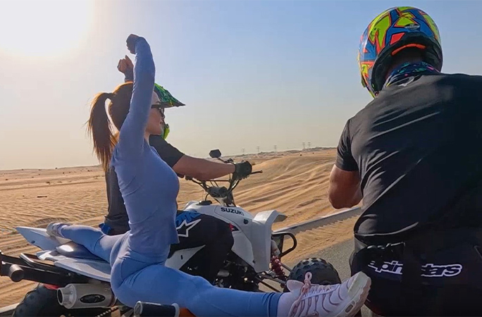 Yara performing the splits between two moving ATVs