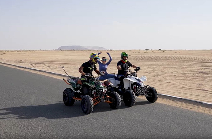 Yara performing the splits between two moving ATVs