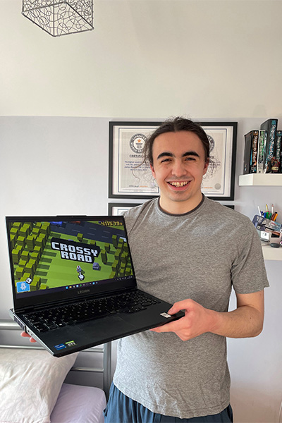 Joshua holding his laptop
