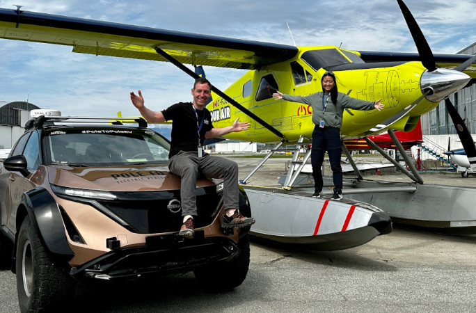 Chris and Julie Ramsey posing with their car and a plane