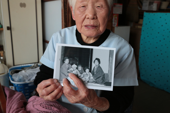 Shitsui Hakoishi holding an old family photo