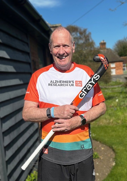 Andy smiling holding a hockey bat