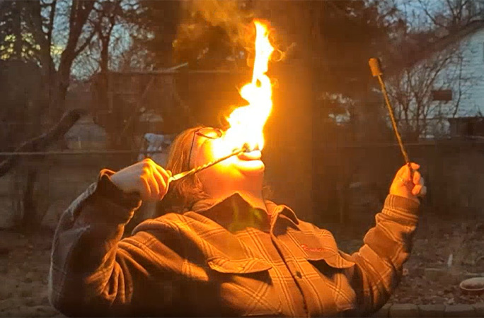 Raederle holding a flame on her tongue