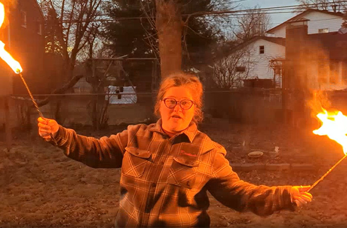 Raederle holding two flames