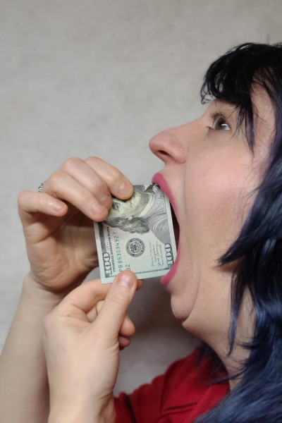 Marie with an 100 dollar bill in her mouth