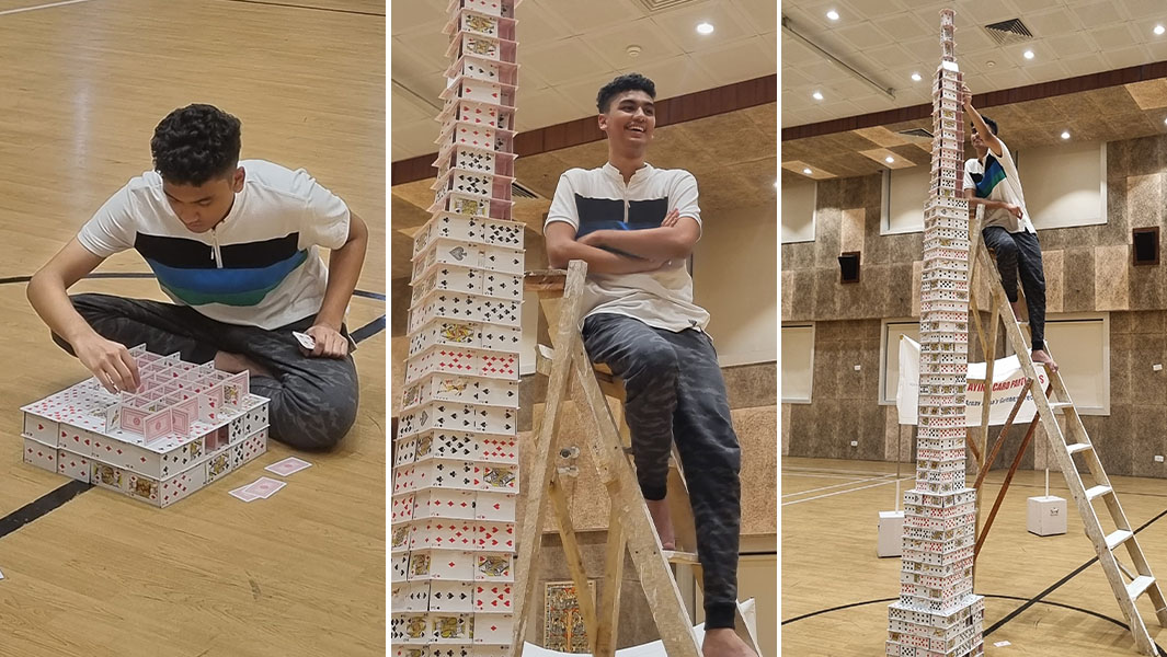 Arnav building his card towers and posing with it