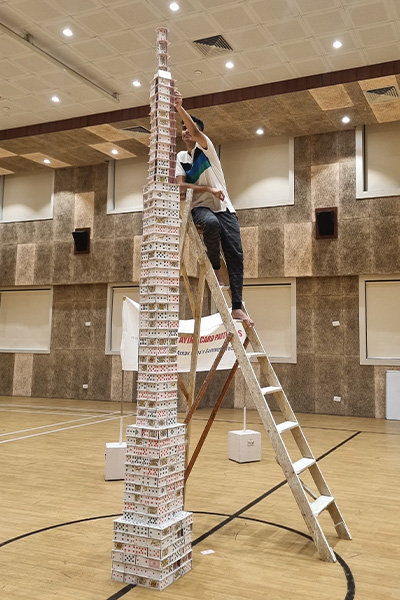 Arnav on a ladder building his tower