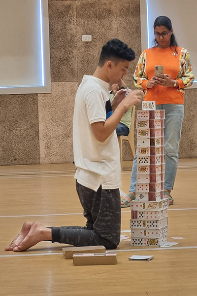 Arnav on his knees building his one hour tower
