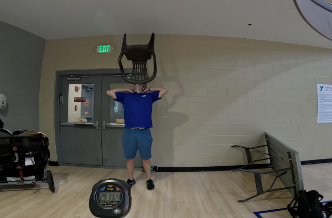 David Rush with bent arms balancing his chair