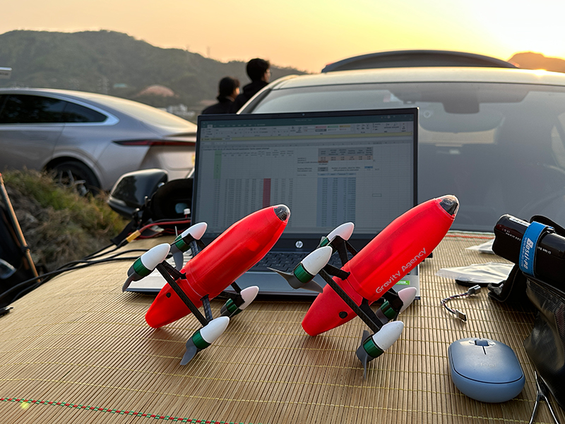  two remote controlled microdrone quadcopters in front of the computer