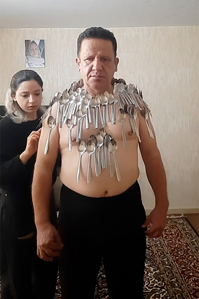 Abolfazl with his chest covered in spoons