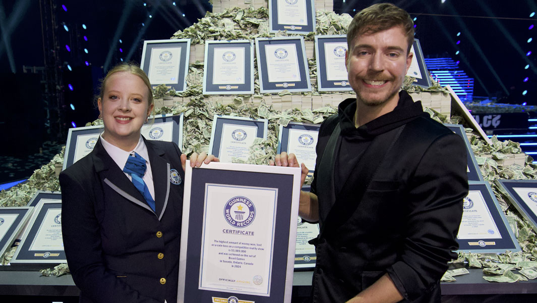 MrBeast with GWR's Emma Salt, a pile of cash and lots of GWR certificates