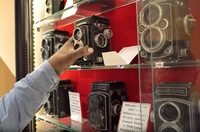 reaching for a camera on the shelf