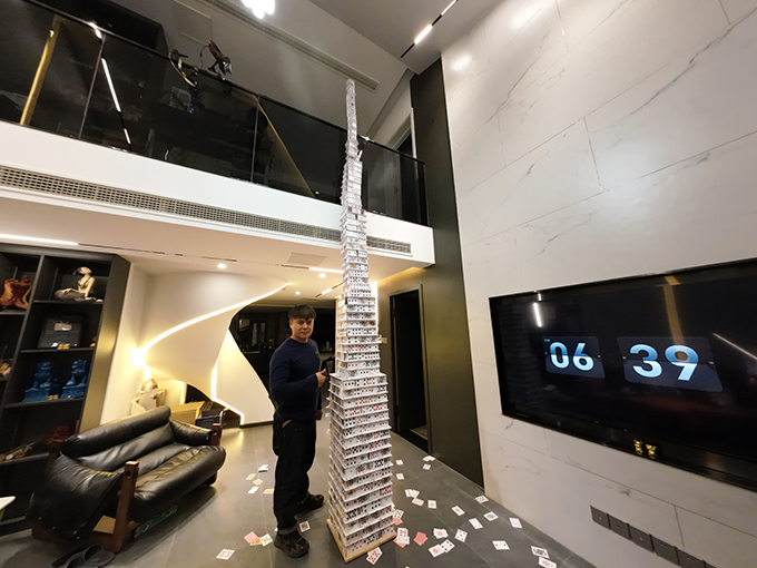 tianrui-standing-next-to-the-tower-of-playing-cards-thumb-up