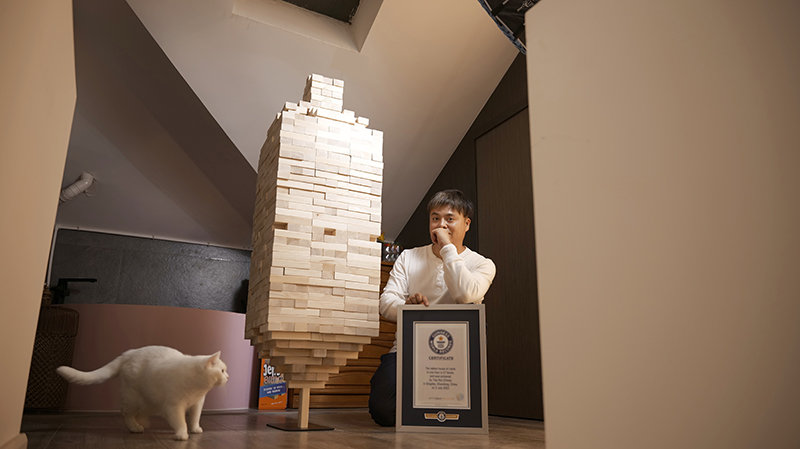 tiantui-sitting-next-to-the-jenga-tower-holding-GWR-certificate