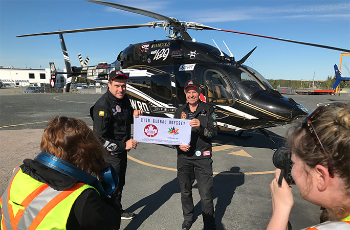 Steven and Bob being photographed by their helicopter