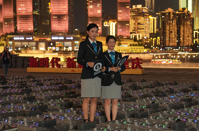 adjudicators standing amongst drones lined up on the ground