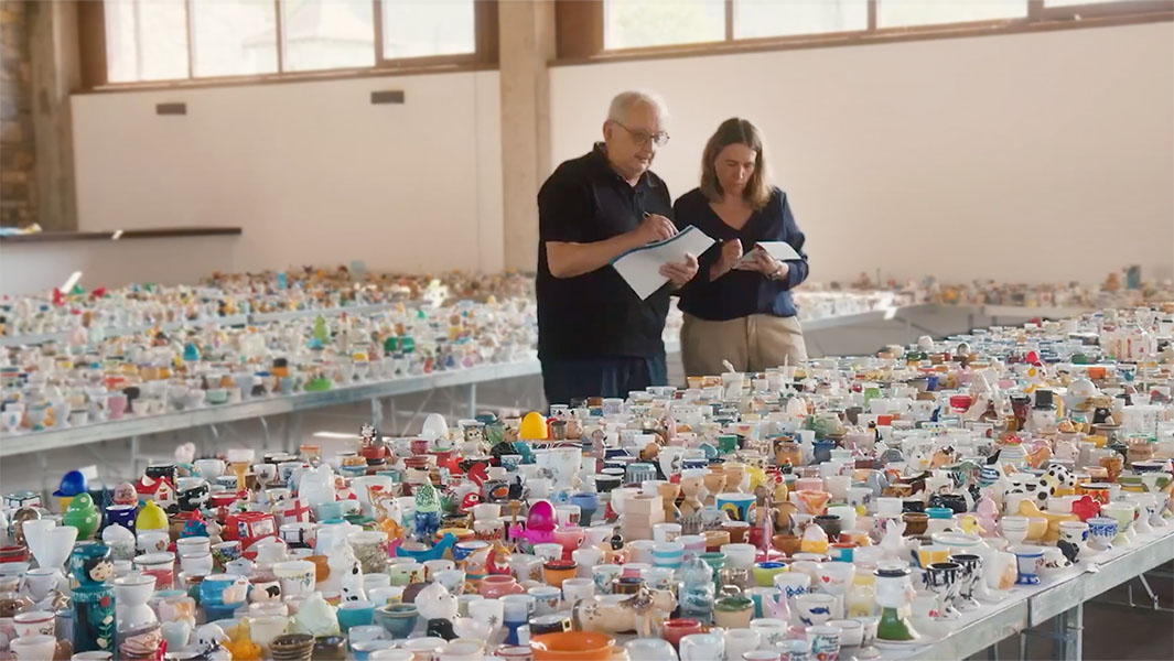 Two people counting the egg cup collection