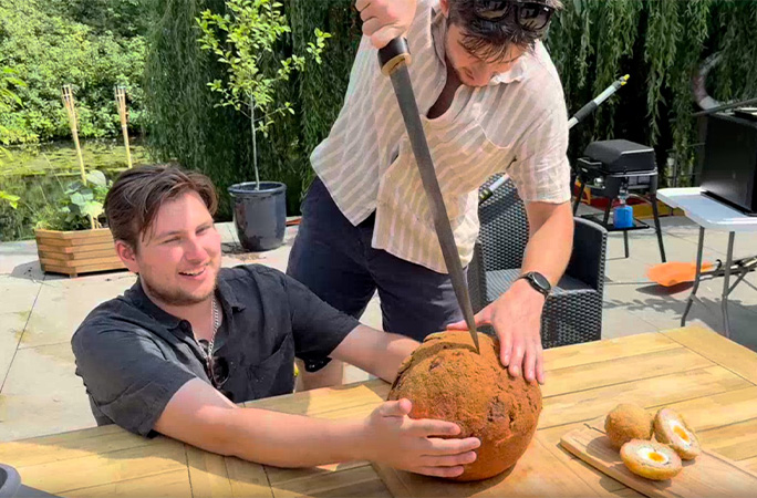 largest scotch egg being cut with a sword