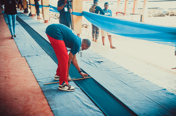 Samuel bending over working on the material