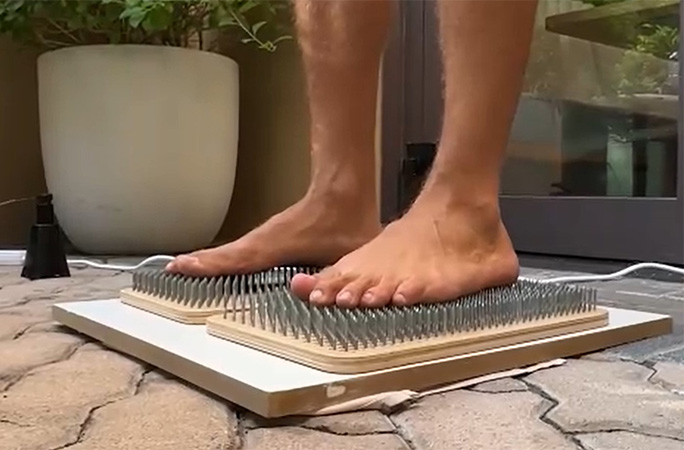 close up of feet on nail board