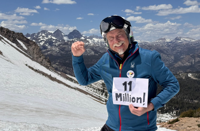 Tom holding up a sign for his 11 millionth foot skiied