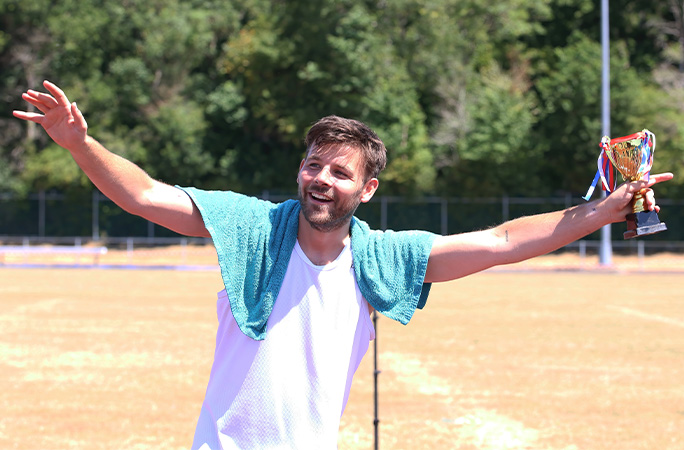 Tom celebrating holding a trophy