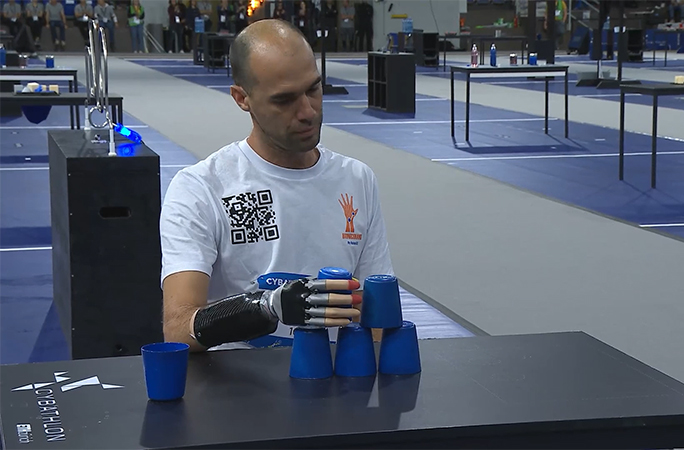 someone stacking cups with a bionic arm