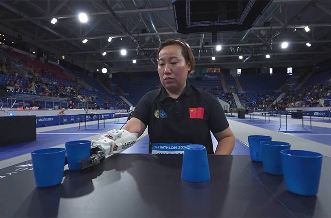 someone stacking cups with bionic arm