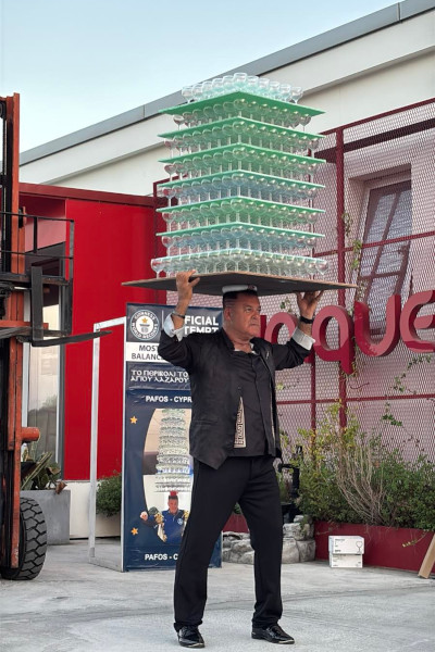 Ari holding the wine glasses with his heads and balancing