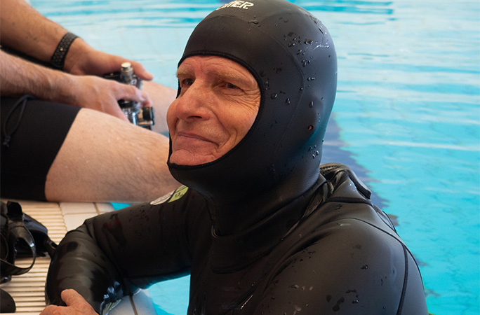 diver smiling by the side of the pool