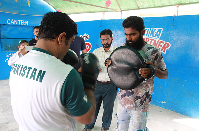 Muhammad punching a pad being held by another man