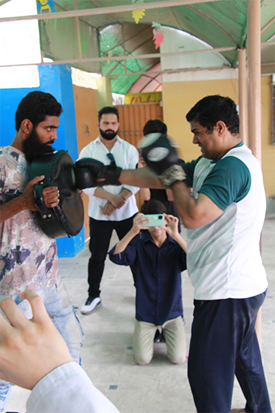 Muhammad punching a pad being held by another man