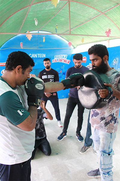 Muhammad punching a pad being held by another man