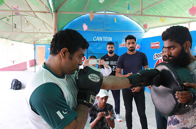 Muhammad punching a pad being held by another man