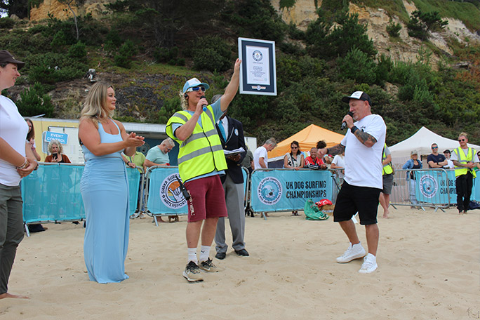 the-organizer-of-the-uk-dog-surfing-championships-mark-reeves-accepts-one-of-his-guinness-world-records-certificates