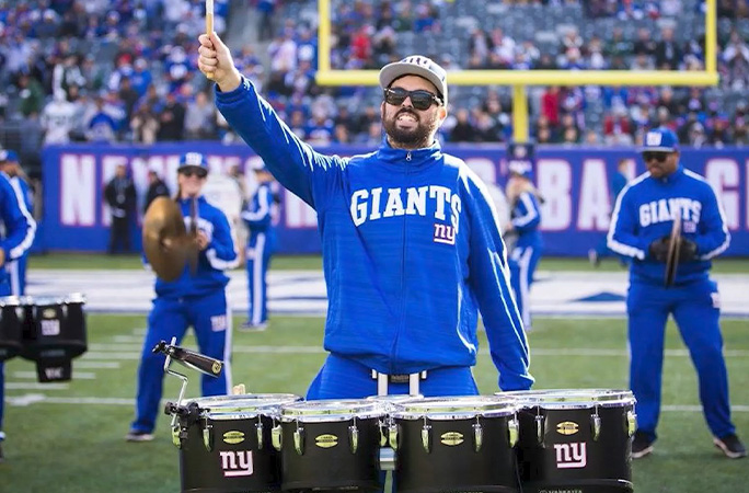 Eric performing drums on a football field