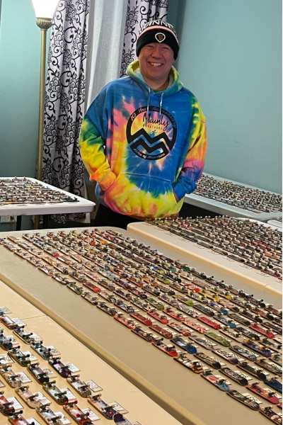 Sonny smiling with his skateboard collection