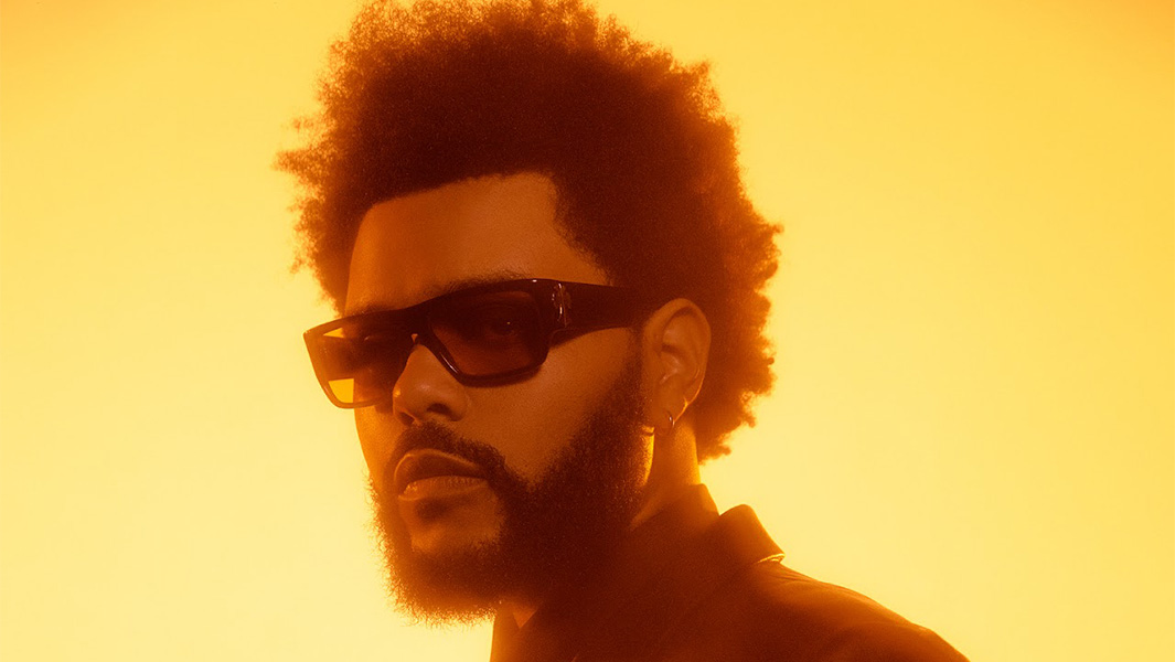 The Weeknd wearing sunglasses pictured against a yellow background
