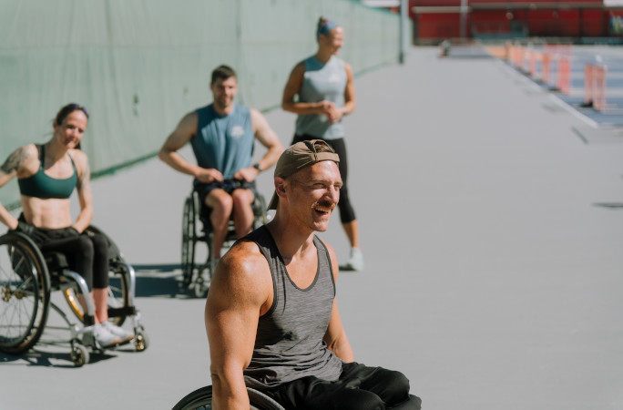 Mike smiling with other athletes in wheelchairs