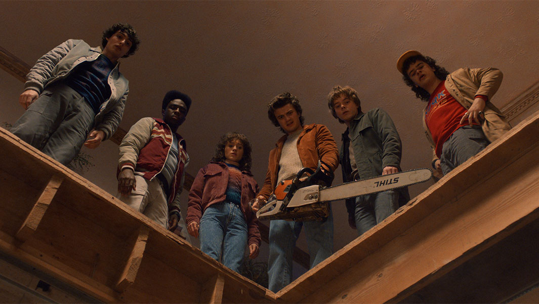 Stranger Things cast looking over balcony
