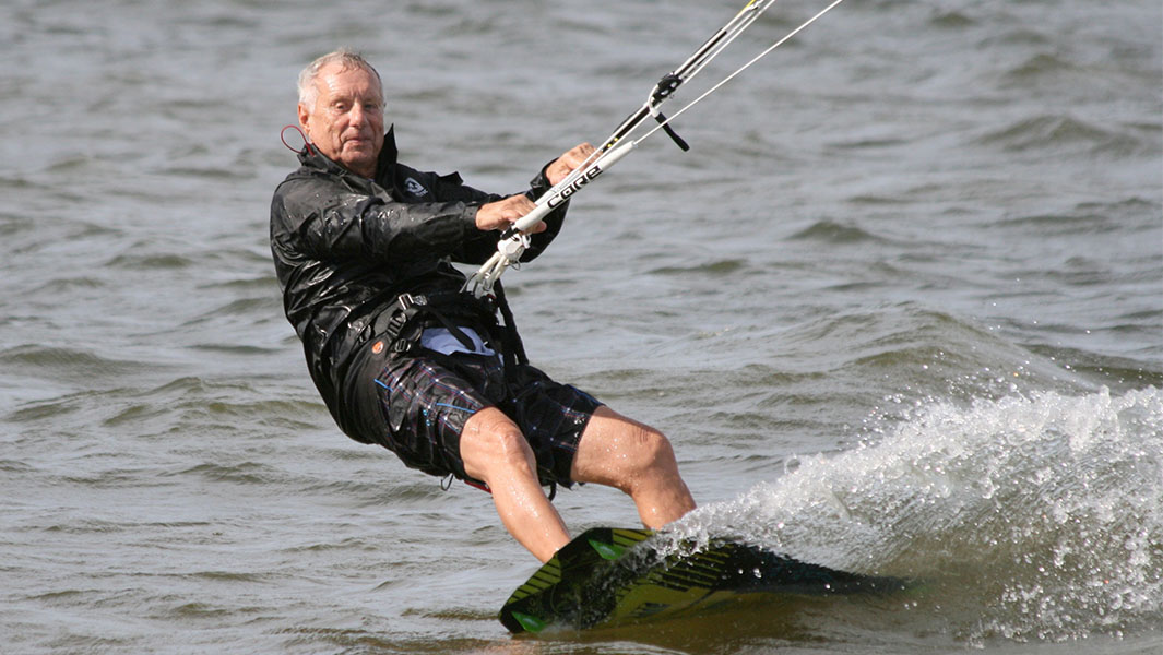 split image of Rick kite surfing and sitting with his board