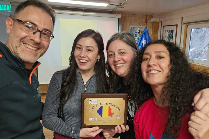 Diana and Stefan taking a selfie with fans and holding a plaque saying 'Road to Freedom'