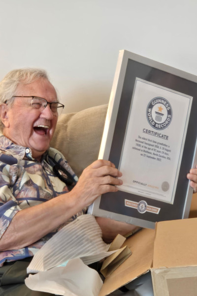 Normand laughing and holding his GWR certificate out of the box